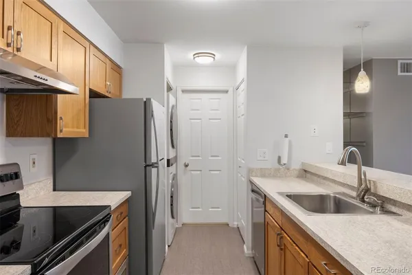 a kitchen that has a sink a stove and a refrigerator