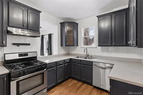 a kitchen with stainless steel appliances a sink stove and cabinets
