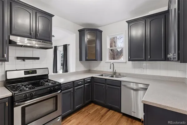 a kitchen with stainless steel appliances a sink stove and cabinets