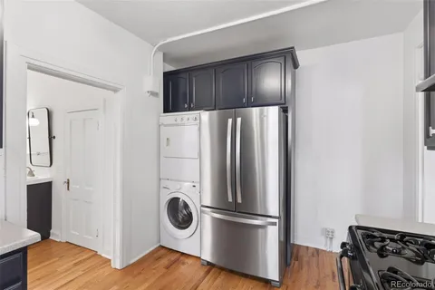 a kitchen with a refrigerator and wooden floor