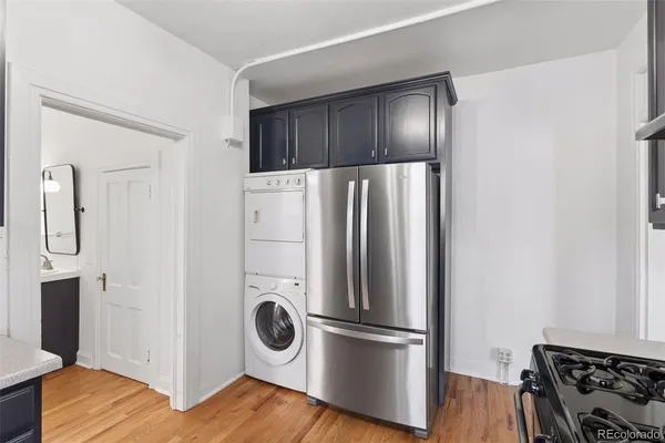 a kitchen with a refrigerator and wooden floor