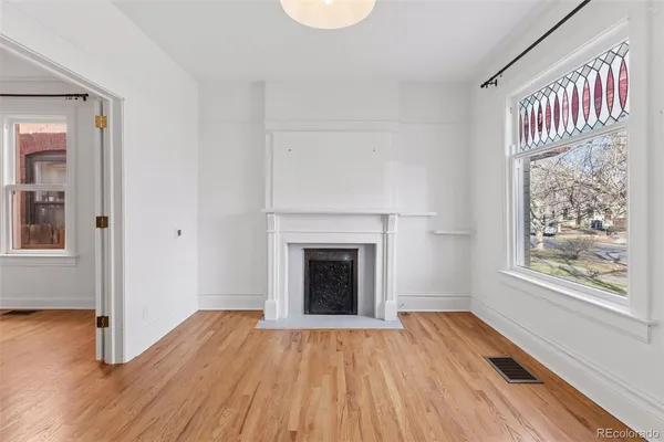 a view of a livingroom with wooden floor and a fireplace