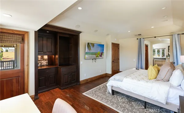 a spacious bedroom with a bed and a refrigerator