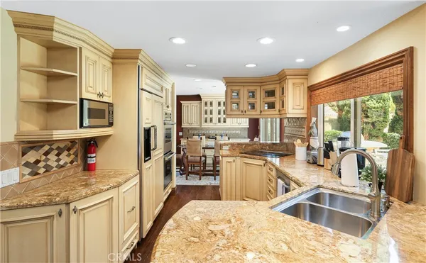 a kitchen with stainless steel appliances granite countertop a sink stove and cabinets