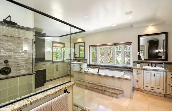 a large kitchen with kitchen island a large counter top space a sink a window and stainless steel appliances