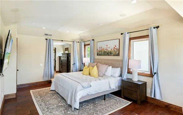 a bedroom with a bed rug and wooden floor