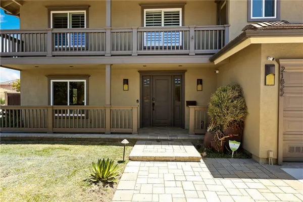 a view of a house with a large window and wooden fence