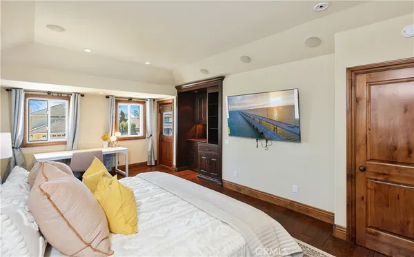 a bedroom with a large bed and a flat tv screen on dresser