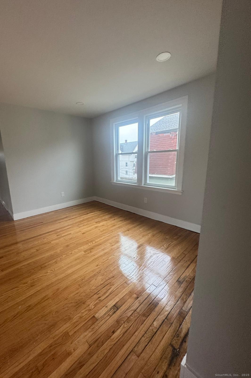 60 Arnold Street Hartford, CT 06106 - Photo 4 of 5 an empty room with wooden floor and windows