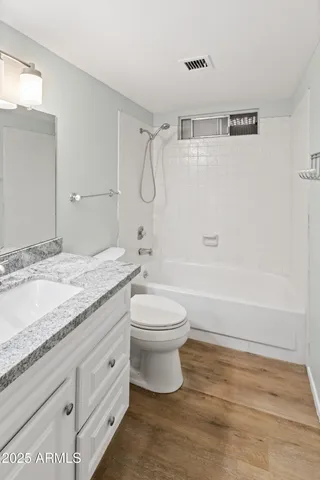 a bathroom with a granite countertop sink toilet a mirror and shower