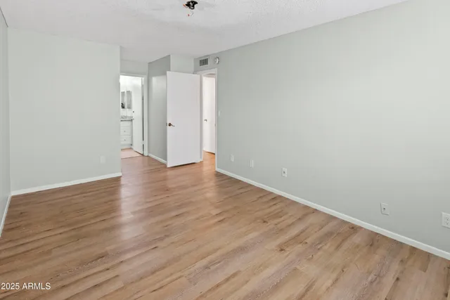 a view of an empty room with wooden floor