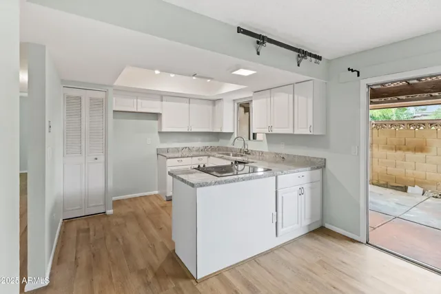 a kitchen with a sink cabinets stainless steel appliances and wooden floor