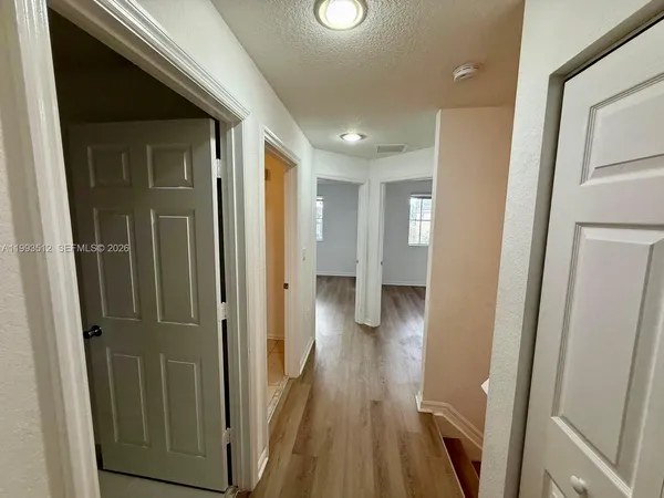 a view of a hallway with wooden floor