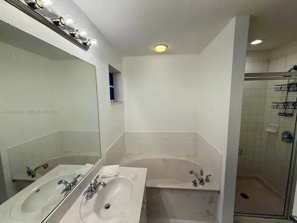 a bathroom with a tub sink and shower