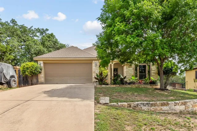 a front view of a house with a yard garage and outdoor seating