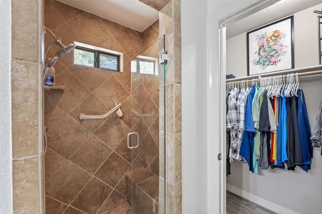 a view of walk in closet with clothes