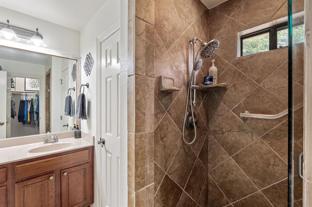 15508 Checotah Drive Austin, TX 78734 - Photo 15 of 23 a bathroom with a shower sink and mirror