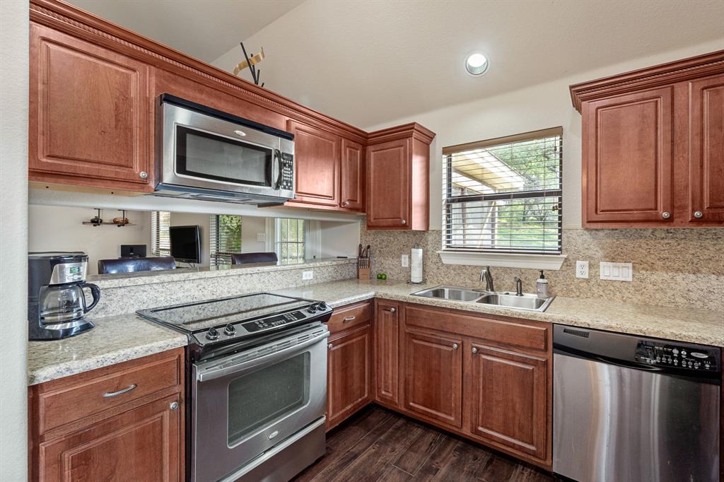 15508 Checotah Drive Austin, TX 78734 - Photo 6 of 23 a kitchen with stainless steel appliances granite countertop a sink stove and microwave