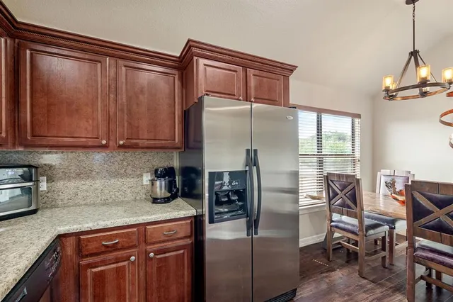 a kitchen with stainless steel appliances granite countertop a refrigerator a sink a stove and island