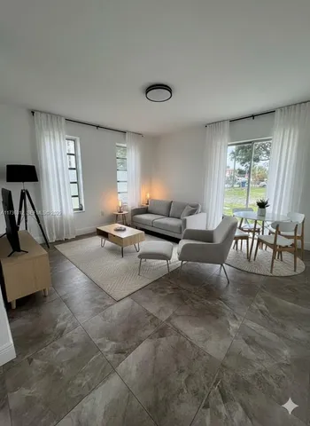 a living room with furniture and a large window