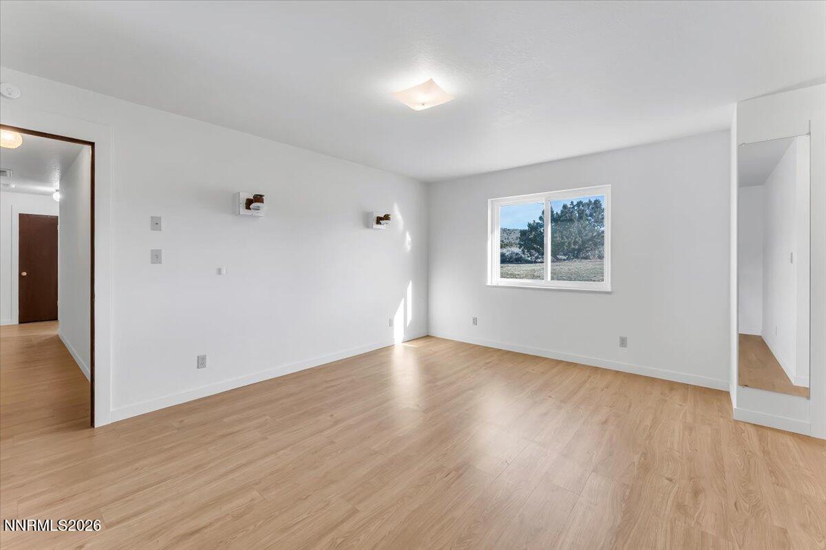 1220 Mineral Flat Road Reno, NV 89506 - Photo 20 of 50 an empty room with wooden floor and windows