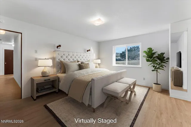 a bedroom with a large bed and a potted plant