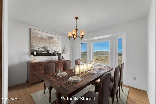 a dining room with furniture a large window and wooden floor