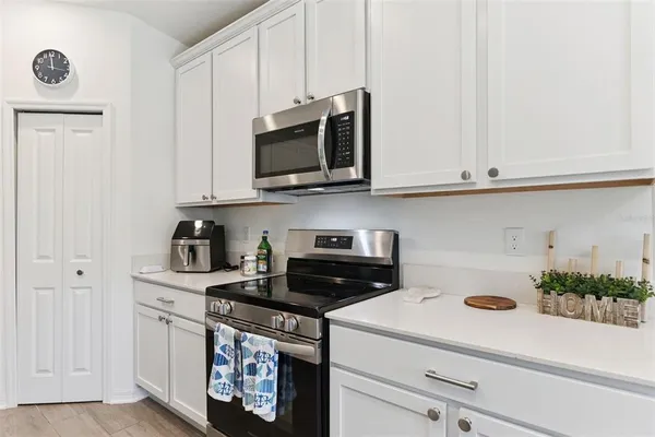 a kitchen with stainless steel appliances granite countertop a sink a stove and microwave