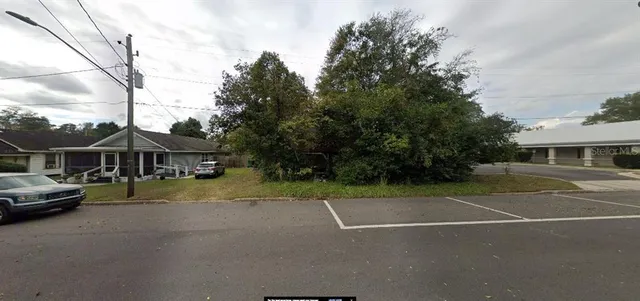 a view of a tennis ground with large trees