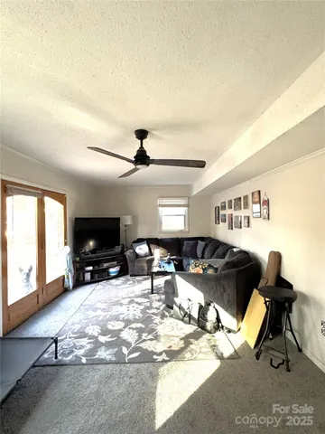 a living room with furniture a flat screen tv and a large window
