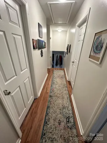 a view of a hallway with wooden floor and stairs