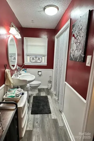 a bathroom with a toilet a sink and a mirror