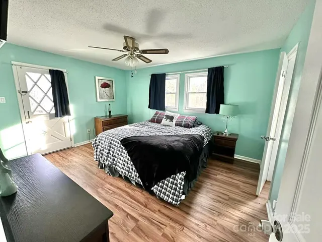 a bedroom with a bed window and a flat screen tv