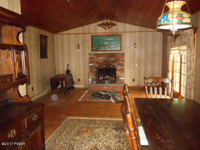 207 Aspen Road Dingmans Ferry, PA 18328 - Photo 12 of 22 a living room with furniture a fireplace and a chandelier