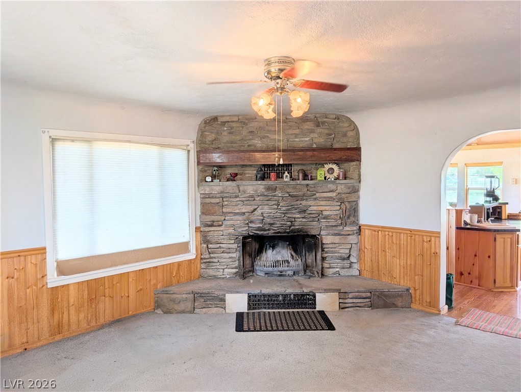 997 Phillips Street Panaca, NV 89042 - Photo 5 of 19 A corner stone fireplace anchors this cozy living space with warm wood paneling.