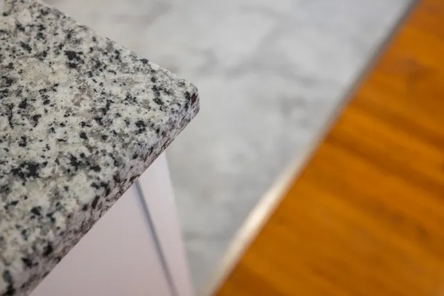 a kitchen with granite countertop a sink cabinets and wooden floor