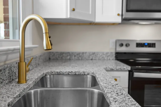 a close view of a sink a faucet and appliance in the kitchen