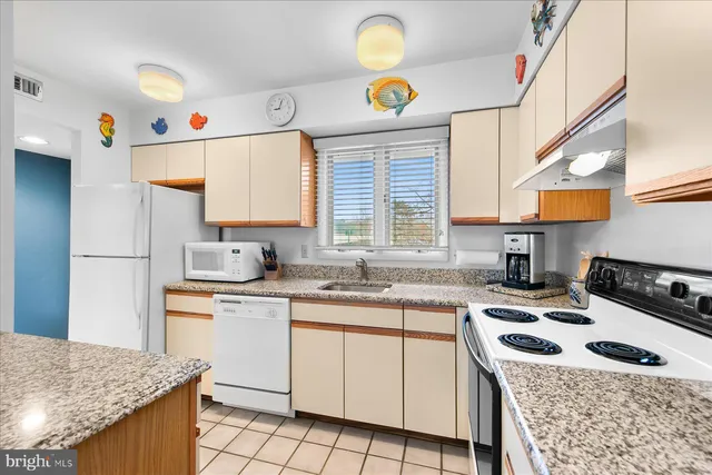 a kitchen with a sink a stove a refrigerator and cabinets