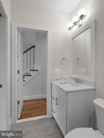 a bathroom with a sink a toilet and a mirror