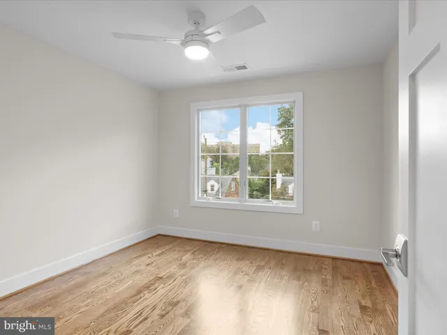 an empty room with a window and wooden floor