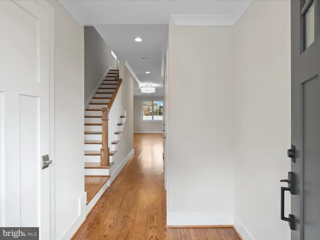 a view of a hallway with wooden floor and entryway