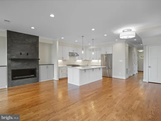a view of kitchen with kitchen island wooden floor center island and appliances