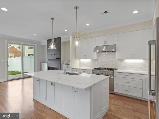 a kitchen with stainless steel appliances granite countertop a stove a sink and a refrigerator