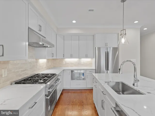 a kitchen with a sink stove top oven and refrigerator