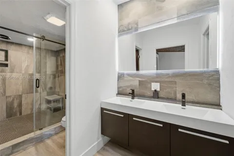 a bathroom with a double vanity sink mirror and shower