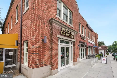 a view of a dinning tables and chairs in the patio in front of a building