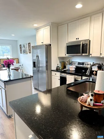 a kitchen with stainless steel appliances granite countertop a sink refrigerator and microwave