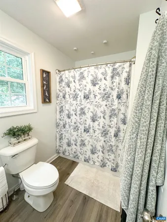 a bathroom with a toilet and a shower curtain