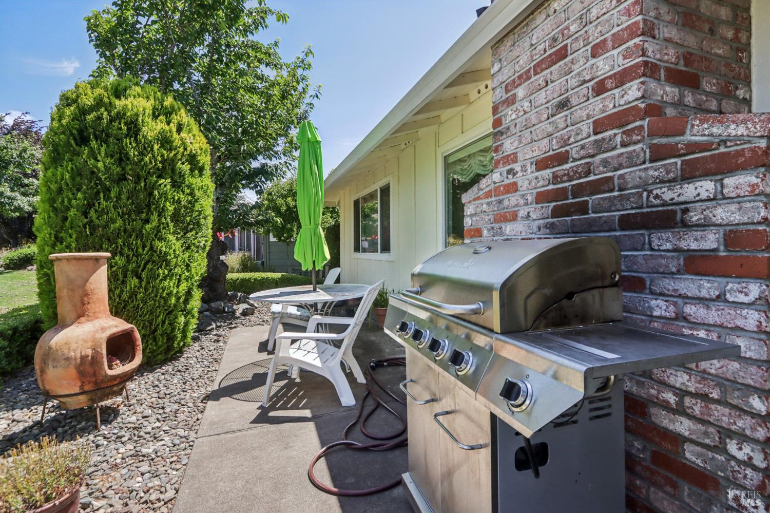 322 Mockingbird Circle Santa Rosa, CA 95409 - Photo 37 of 44 a view of a patio with table and chairs potted plants and a large tree