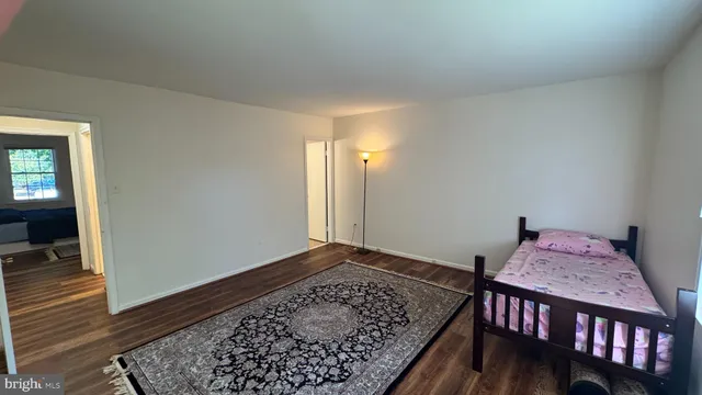 a bedroom with bed and wooden floor